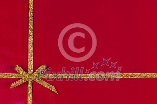 Red background of present wrapped with gold ribbon and bow