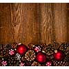 Rustic wood background with Christmas ornaments and pine cones