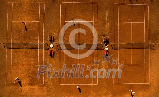 Aerial shot of a tennis courts with players in warm evening sunlight Aerial shot of a tennis courts with players in warm evening sunlight