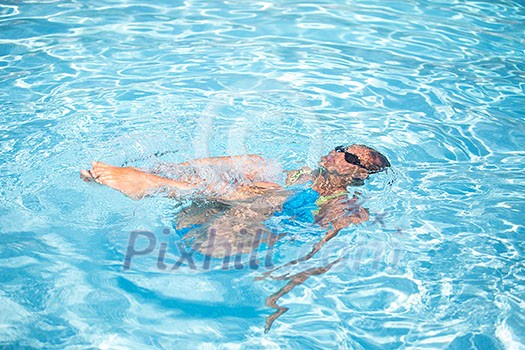 Young woman in a swimming pool performing some synchronized swimming drills