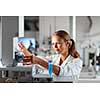 Portrait of a female researcher doing research in a chemistry lab (shallow DOF; color toned image)