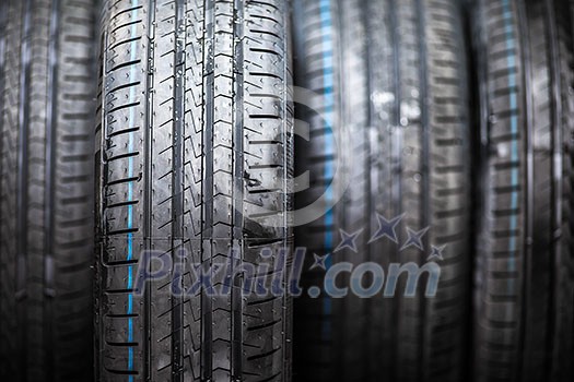 Stack of brand new high performance car tires on clean low-key black studio background Stack of brand new high performance car tires on clean low-key black studio background