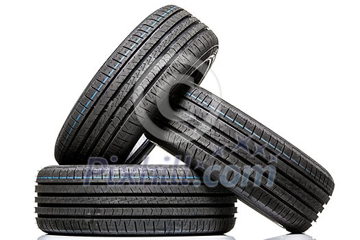 Stack of brand new high performance car tires on clean high-key white studio background