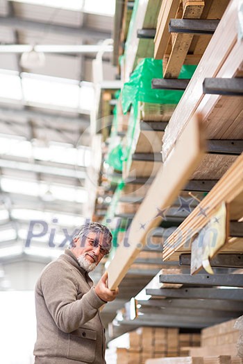 Man choosing and buying construction wood in a DIY store for his DIY home re-modeling project Man choosing and buying construction wood in a DIY store for his DIY home re-modeling project