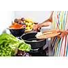 Young woman cooking in her modern kitchen (shallow DOF; color toned image)