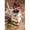 Muesli, fresh berries and yogurt in glass mason jar on wooden table. Healthy breakfast with Homemade granola