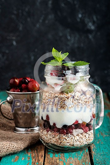 Muesli, fresh berries and yogurt in glass mason jar on wooden table. Healthy breakfast with Homemade granola Muesli, fresh berries and yogurt in glass mason jar on wooden table. Healthy breakfast with Homemade granola