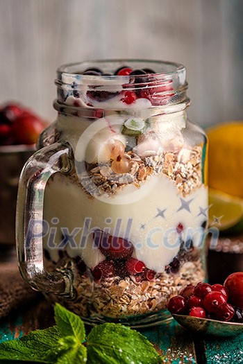Muesli, fresh berries and yogurt in glass mason jar on wooden table. Healthy breakfast with Homemade granola Muesli, fresh berries and yogurt in glass mason jar on wooden table. Healthy breakfast with Homemade granola