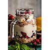 Muesli, fresh berries and yogurt in glass mason jar on wooden table. Healthy breakfast with Homemade granola