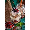 Muesli, fresh berries and yogurt in glass mason jar on wooden table. Healthy breakfast with Homemade granola