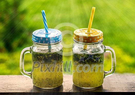 Summer drink lemonade with lemon and mint in mason jar outdoor. Summer drink lemonade with lemon and mint in mason jar outdoor.