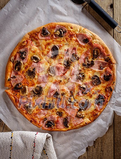 Delicious fresh pizza with mushrooms and bacon on a wooden background. Top view.