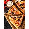 Homemade sleced delicious pizza with bacon and mushroom on wooden background. Italian cuisine.