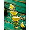 Mexican Gold Tequila with lime and salt on wooden table, selective focus.