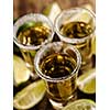 Mexican Gold Tequila with lime and salt on wooden table, selective focus. Top view. Shallow depth of field.