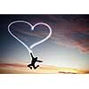 Young girl jumping high in sky and drawing love sign