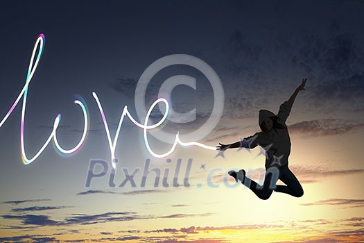 Young girl jumping high in sky and drawing love word