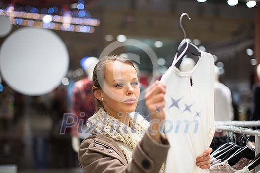 Young woman shopping in a fashion store (color toned image; shallow DOF) Young woman shopping in a fashion store (color toned image; shallow DOF)