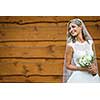 Gorgeous bride on her wedding day  holding her lovely bouquet (color toned image; shallow DOF)