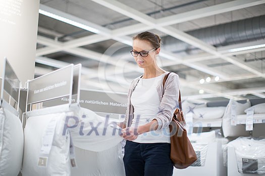 Pretty, young woman choosing the right furniture for her apartment in a modern home furnishings store (color toned image; shallow DOF) Pretty, young woman choosing the right furniture for her apartment in a modern home furnishings store (color toned image; shallow DOF)