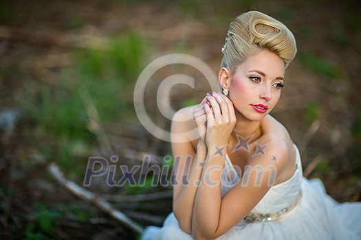 Lovely bride on her wedding day outdoors in a forest (color toned image; shallow DOF)