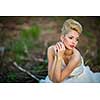 Lovely bride on her wedding day outdoors in a forest (color toned image; shallow DOF)