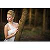 Lovely bride on her wedding day outdoors in a forest (color toned image; shallow DOF)