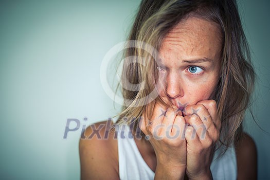 Young woman suffering from a severe depression, anxiety/sudden fear (very harsh lighting is used on this shot to underline/convey the gloomy mood of the scene; color toned image) Young woman suffering from a severe depression, anxiety/sudden fear (very harsh lighting is used on this shot to underline/convey the gloomy mood of the scene; color toned image)