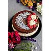 Chocolate raspberry cream cake with flowers on a grey background