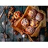 Chocolate muffins with powdered sugar on the wooden table, rustic style. New Year's Concept.