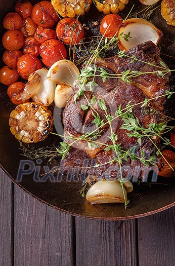 Beef steak with vegetables on a frying pan