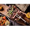 Grilled steak sliced on a cutting board. Entrecote with vegetables on a wooden background. 
