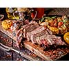 Grilled steak sliced on a cutting board. Entrecote with vegetables on a wooden background. 