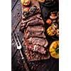 Grilled steak sliced on a cutting board. Entrecote with vegetables on a wooden background. View from above