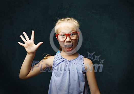 Genius girl in red glasses near blackboard with formulas