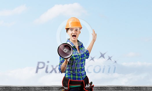 Young woman builder screaming emotionally in megaphone Young woman builder screaming emotionally in megaphone