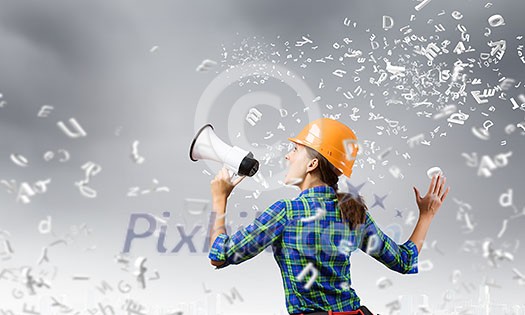 Young woman builder screaming emotionally in megaphone Young woman builder screaming emotionally in megaphone