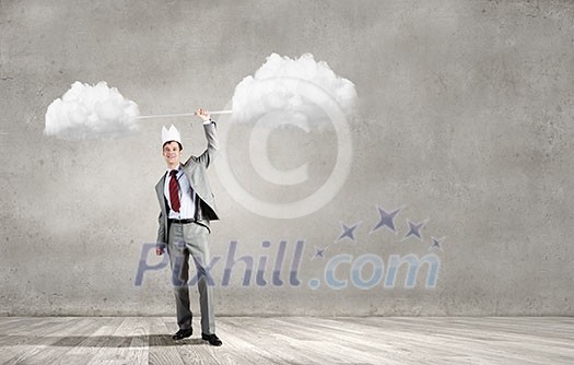 Young businessman in paper crown lifting barbell above head