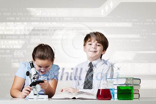 Cute girl and boy at chemistry lesson making tests Cute girl and boy at chemistry lesson making tests