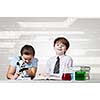 Cute girl and boy at chemistry lesson making tests