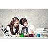 Cute girl and boy at chemistry lesson making tests