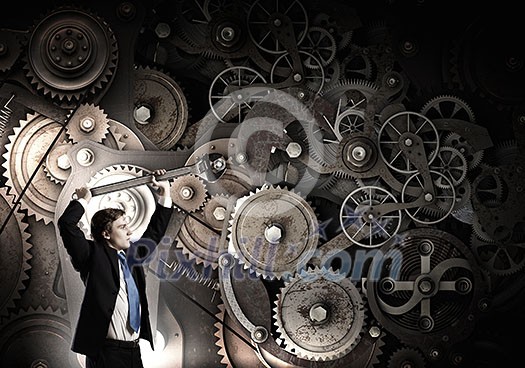 Young businessman fixing gears mechanism with wrench Young businessman fixing gears mechanism with wrench