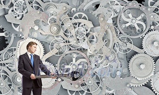 Young businessman fixing gears mechanism with wrench Young businessman fixing gears mechanism with wrench