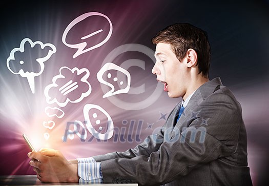 Young businessman looking shocked into tablet pc