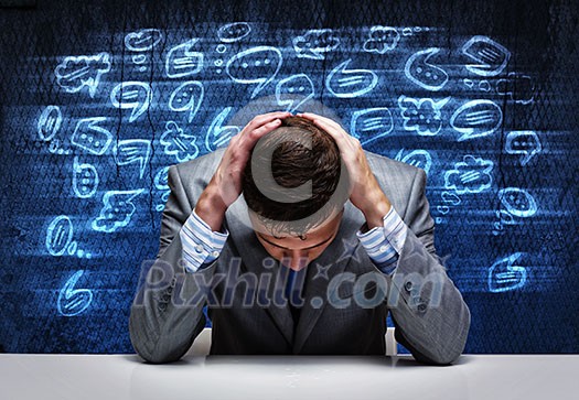 Troubled young businessman covering head with hands