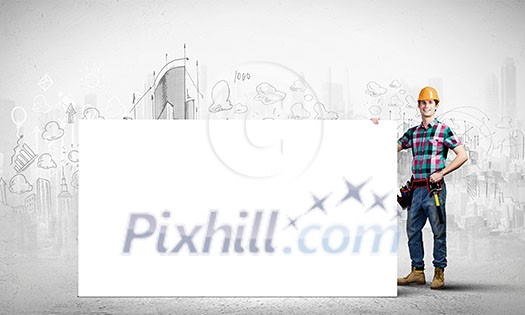 Young repairman holding white blank banner. Place for text Young repairman holding white blank banner. Place for text