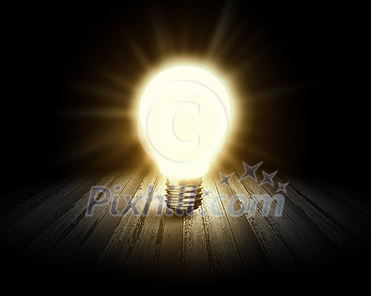 Conceptual image with light bulb and wooden surface