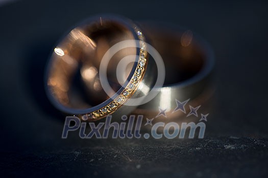 Wedding day details - two lovely golden wedding rings awaiting their moment (shallow DOF; color toned image) Wedding day details - two lovely golden wedding rings awaiting their moment (shallow DOF; color toned image)