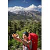 Pretty, young woman hiker taking a selfie photo with her smart phone in high mountains