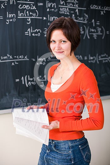 Pretty, young college student writing on the chalkboard/blackboard during a math class (color toned image) Pretty, young college student writing on the chalkboard/blackboard during a math class (color toned image)